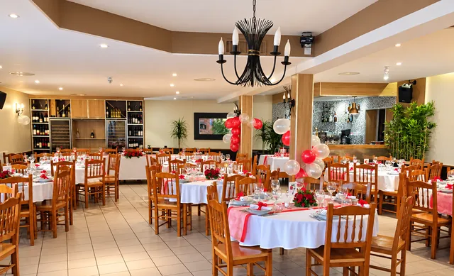 La salle du restaurant, avec la cave à vins et le bar au fond
